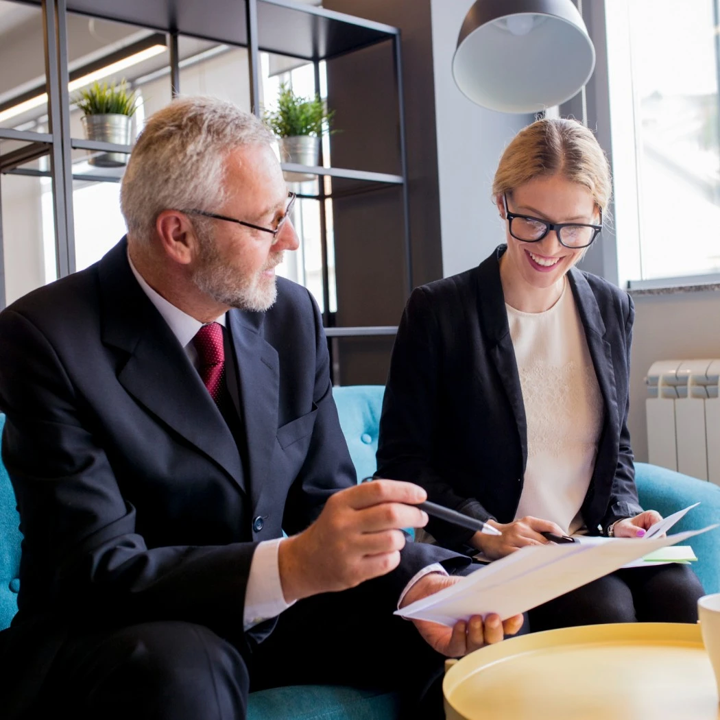 Labour law consultant reviewing statutory compliance documents with corporate client in office