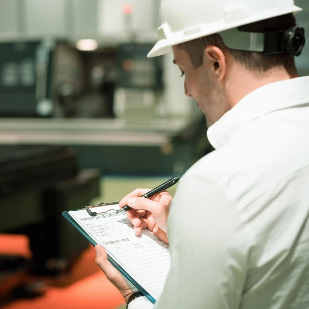 Manufacturing compliance inspector reviewing factory safety checklist